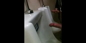 two slim dicks getting wanked at the urinals