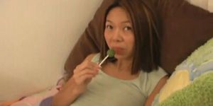 Amateur Asian babe sucks a lolly as she rubs her pussy