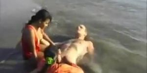 2 Indian girls with white guy in beach have fun blowjob