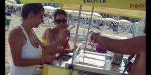 Busty girl selling ice-creams on the beach