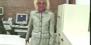 Older blond secretary plays with her wet pink pussy