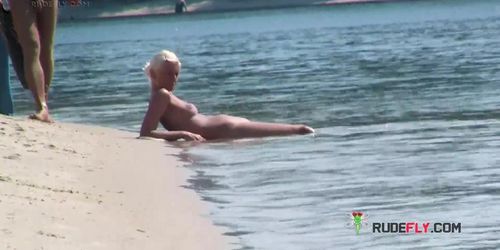 Playful blond nudist teen caught on camera naked at the beach