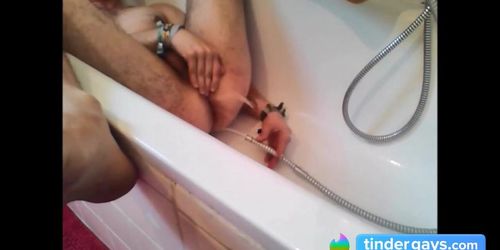 Bi-guy using shower head squirting water enema