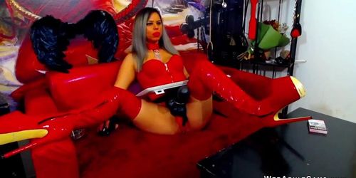 Blonde DomiMarcy in thigh high latex boots and with huge strap on cock posing on webcam