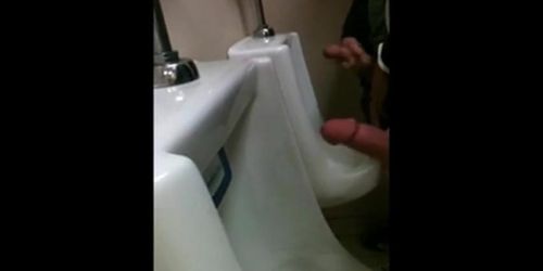 two slim dicks getting wanked at the urinals