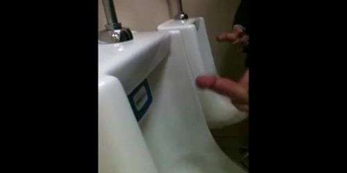 two slim dicks getting wanked at the urinals