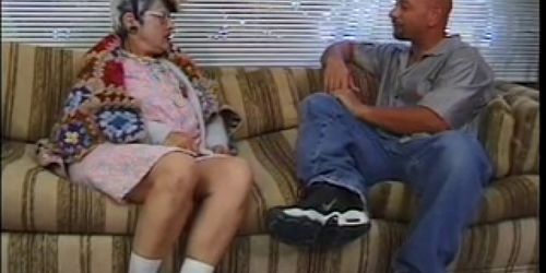 Older woman blows young dude's hard cock on couch