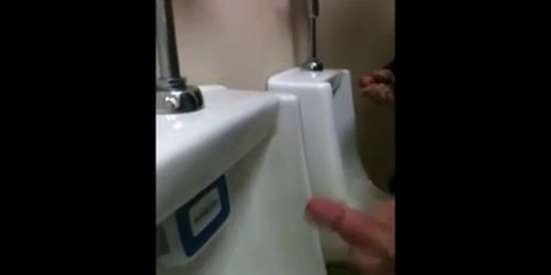 two slim dicks getting wanked at the urinals