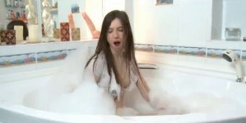 A long-haired natural brunette dildoing in the bath tub