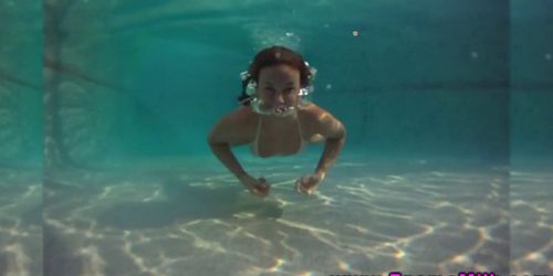 Sport chick pole dances under water in a swimming pool