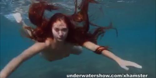 Julia is swimming underwater nude in the sea